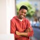 smiling-young-black-man-leaning-against-wall-outsi-2024-10-18-03-22-55-utc.jpg